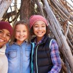 Group Of Children Playing In Forest Camp Together