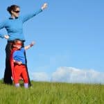 Superhero mother and daughter against dramatic blue sky background with copy space. concept photo of Super hero, girl power, play pretend, childhood, imagination.
