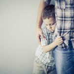 sad son hugging his dad near wall at the day timesad son hugging his dad near wall at the day time